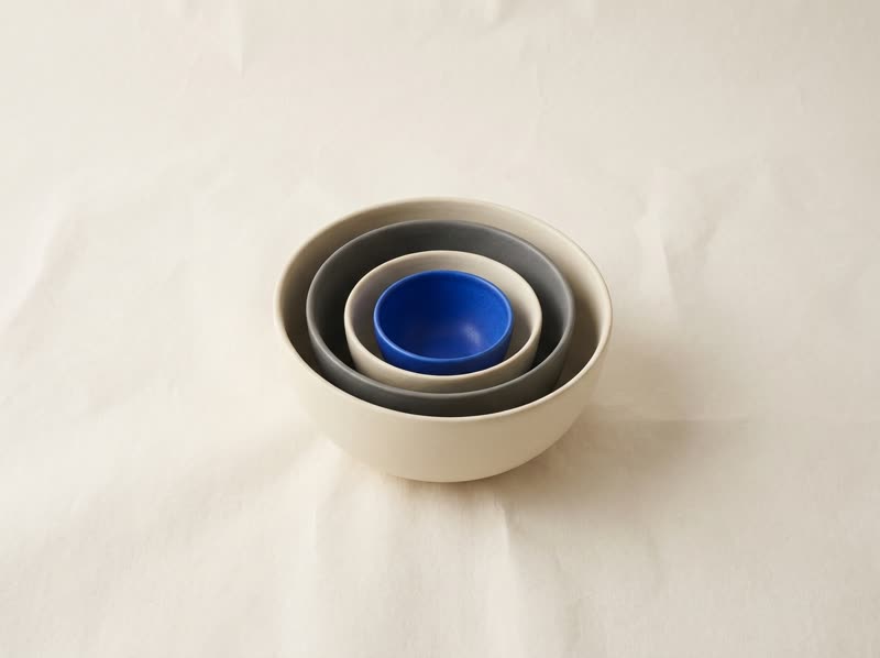Ceramic bowls nested inside one another; the innermost is blue.