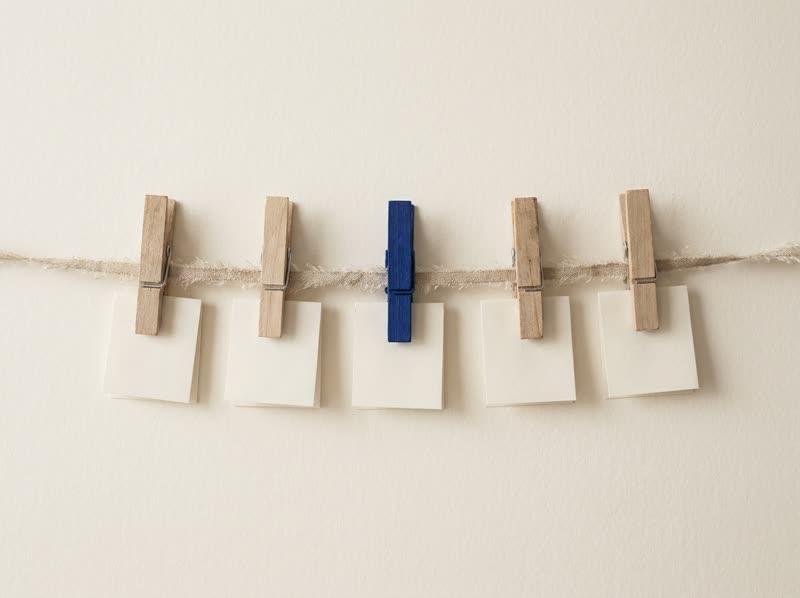 Five clothespins holding notes on a line; the blue one won't be forgotten.